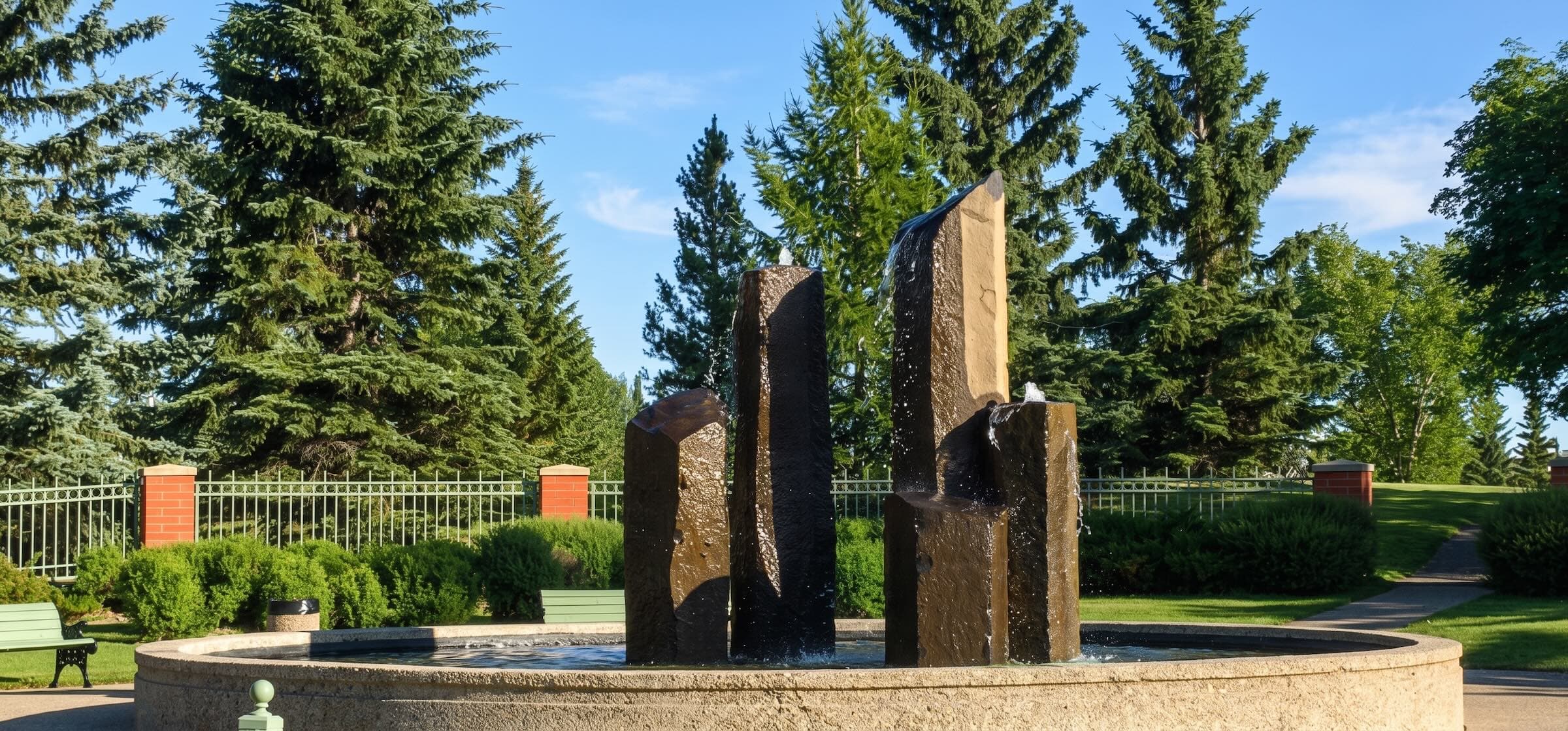 Wedgewood Ravine fountain with brick pillars and evergreen backdrop